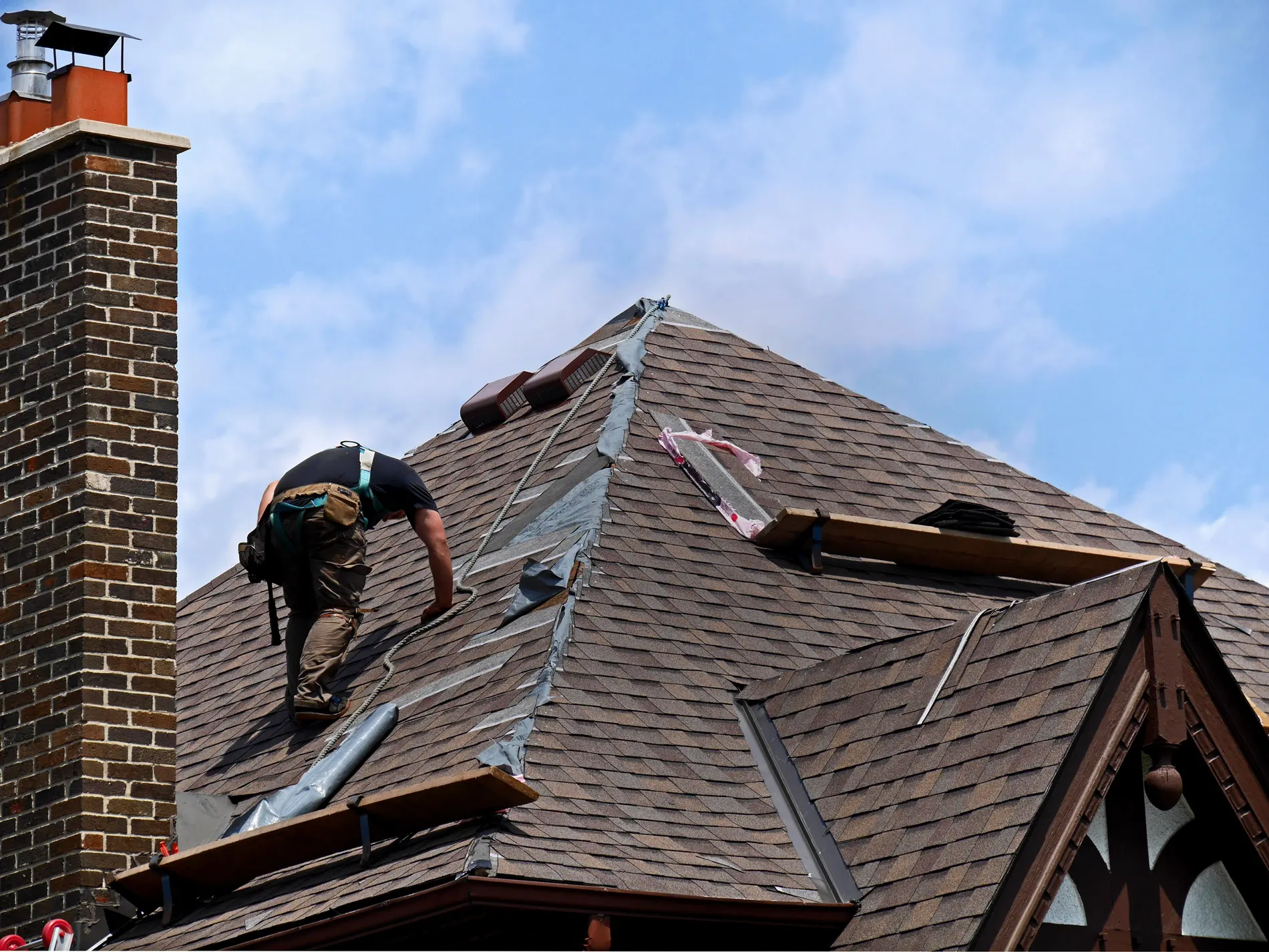 Roofer replacing slates on a pitched roof